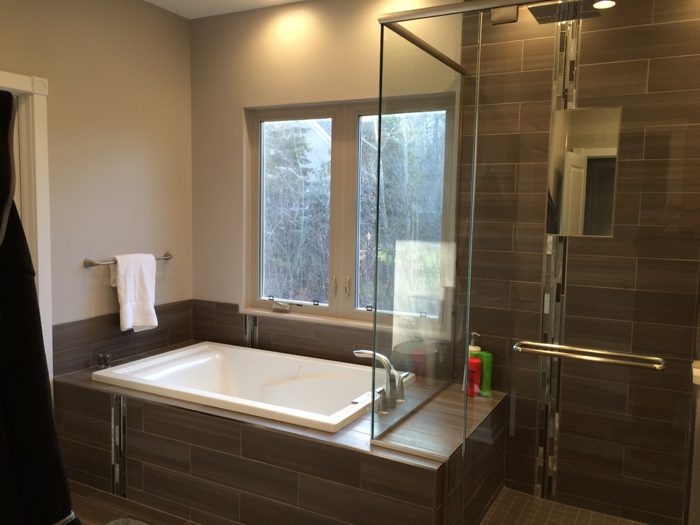 This is an example of a medium sized contemporary ensuite bathroom in Cleveland with raised-panel cabinets, dark wood cabinets, engineered stone worktops, a built-in bath, a two-piece toilet, grey tiles, porcelain tiles, grey walls and porcelain flooring.