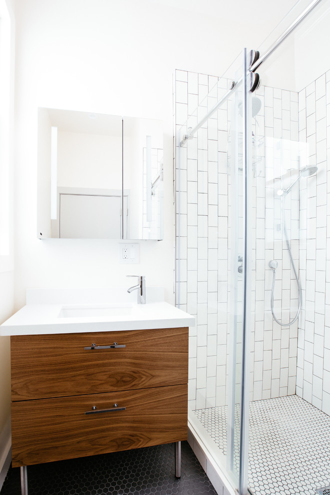 Idée de décoration pour une salle de bain design en bois brun de taille moyenne avec un placard à porte plane, un carrelage noir et blanc, des carreaux de porcelaine, un mur blanc, un sol en carrelage de porcelaine, un lavabo encastré et un plan de toilette en quartz modifié.