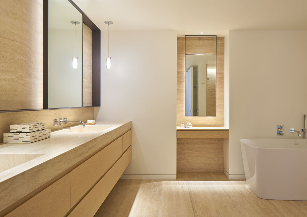Design ideas for a contemporary ensuite bathroom in San Francisco with flat-panel cabinets, light wood cabinets, a freestanding bath, travertine tiles, white walls, travertine flooring and a submerged sink.