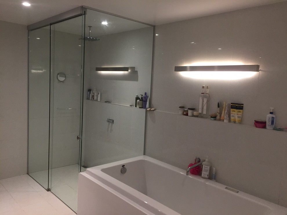 Aménagement d'une petite salle de bain principale moderne avec un combiné douche/baignoire, des carreaux de béton et un plan de toilette en verre.