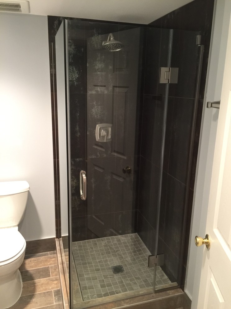 This is an example of a small modern ensuite bathroom in New York with a shower/bath combination, cement tiles, glass worktops and an open shower.