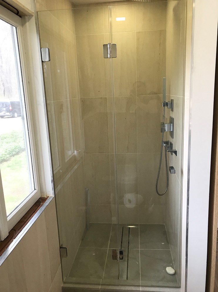 Exempel på ett litet modernt en-suite badrum, med en dusch/badkar-kombination, cementkakel och bänkskiva i glas