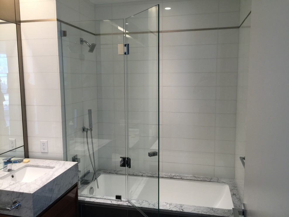 Ispirazione per una stanza da bagno padronale moderna di medie dimensioni con nessun'anta, vasca ad angolo, vasca/doccia, piastrelle di cemento, top in vetro e doccia aperta