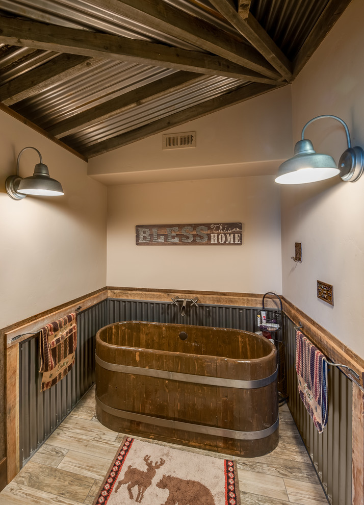 На фото: главная ванная комната в деревянном доме в стиле рустика с отдельно стоящей ванной, бежевыми стенами и бежевым полом с
