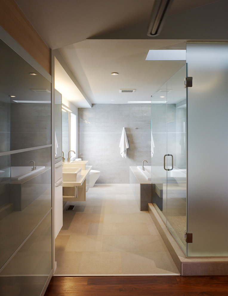 Medium sized modern ensuite bathroom in DC Metro with a vessel sink, flat-panel cabinets, white cabinets, a built-in bath, a corner shower, grey walls, beige floors and a hinged door.