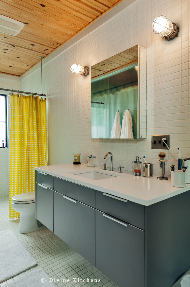 Ispirazione per una grande stanza da bagno minimal con lavabo sottopiano, ante lisce, ante grigie, WC a due pezzi, piastrelle bianche e pareti bianche