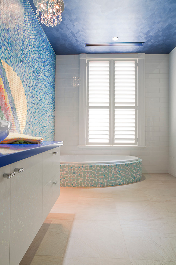 Aménagement d'une grande salle de bain contemporaine pour enfant avec un placard à porte plane, des portes de placard blanches, un plan de toilette en surface solide, un carrelage multicolore, une baignoire posée et mosaïque.