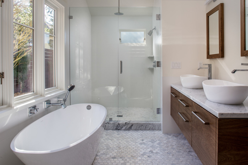 Idéer för att renovera ett funkis badrum, med ett fristående handfat, släta luckor, skåp i mellenmörkt trä, marmorbänkskiva, ett fristående badkar, en dusch i en alkov, vit kakel, porslinskakel, vita väggar och marmorgolv