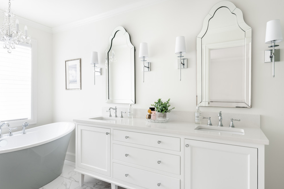 Inspiration for a transitional white floor freestanding bathtub remodel in Vancouver with white cabinets, white walls, an undermount sink, white countertops and beaded inset cabinets
