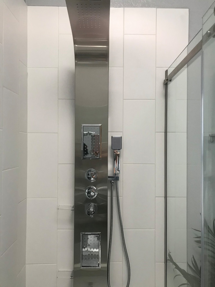 Photo of a medium sized contemporary ensuite bathroom in San Francisco with flat-panel cabinets, grey cabinets, an alcove shower, a two-piece toilet, grey tiles, porcelain tiles, grey walls, porcelain flooring, a submerged sink, engineered stone worktops, white floors, a sliding door, white worktops, a wall niche, double sinks, a built in vanity unit and a vaulted ceiling.