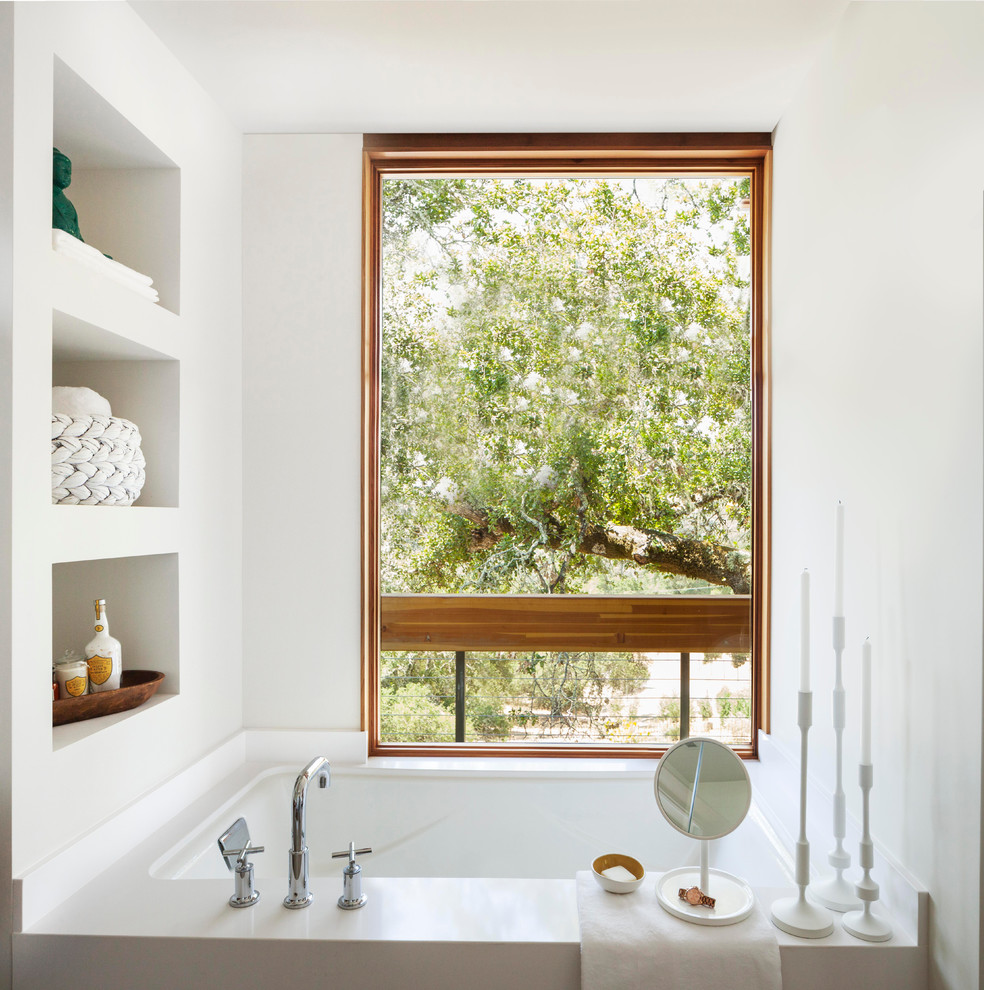 Imagen de cuarto de baño campestre con armarios abiertos, paredes blancas y bañera encastrada sin remate
