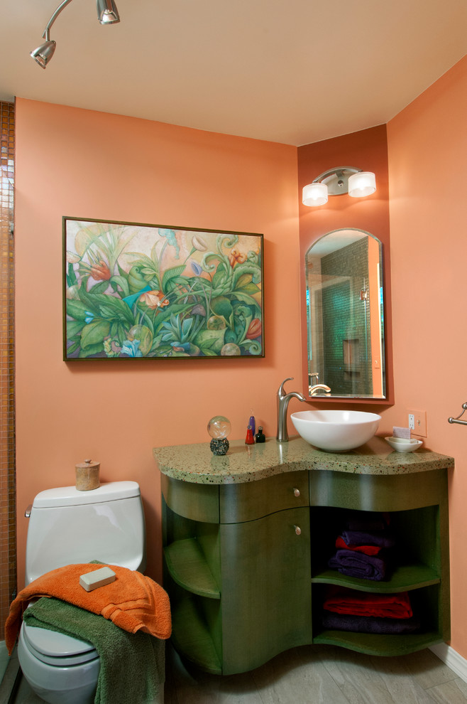 Cette image montre une salle de bain minimaliste de taille moyenne avec un placard en trompe-l'oeil, des portes de placards vertess, WC à poser, un mur rose, une vasque, un sol gris, une cabine de douche à porte battante et un plan de toilette vert.