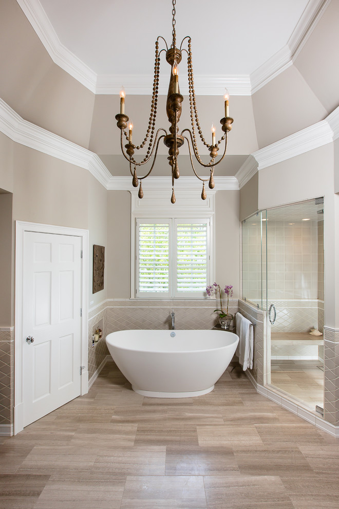 Cette photo montre une salle de bain chic avec une baignoire indépendante, une douche d'angle, un carrelage beige et un mur beige.