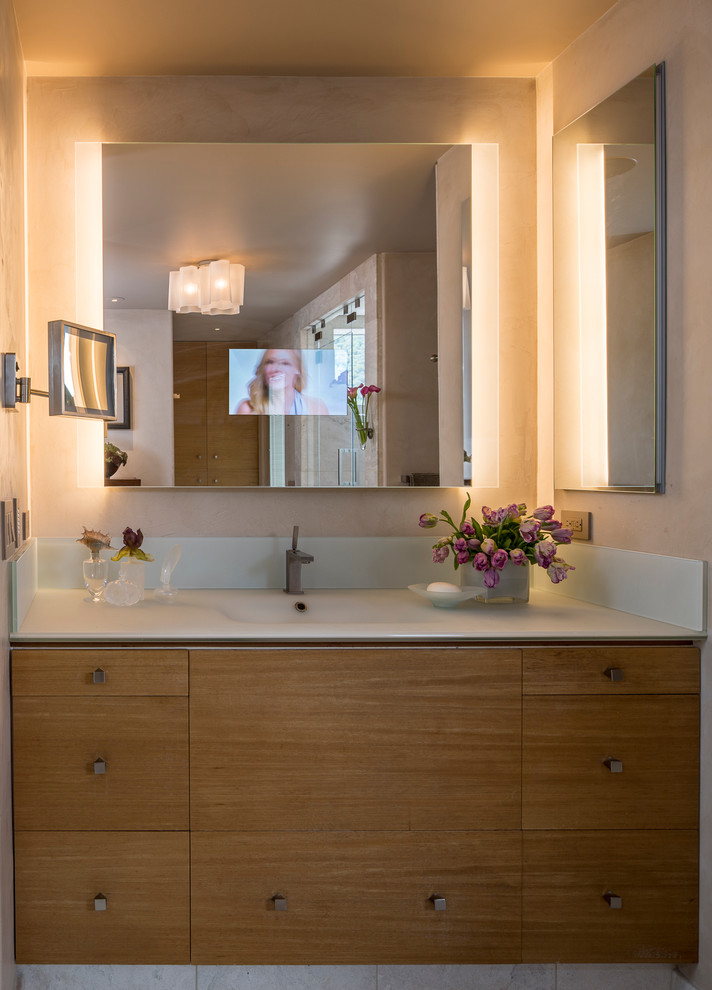 Foto di una stanza da bagno padronale tradizionale con lavabo integrato, ante lisce, ante in legno scuro, top in vetro, doccia alcova, bidè, piastrelle beige, piastrelle in pietra, pareti beige e pavimento in marmo