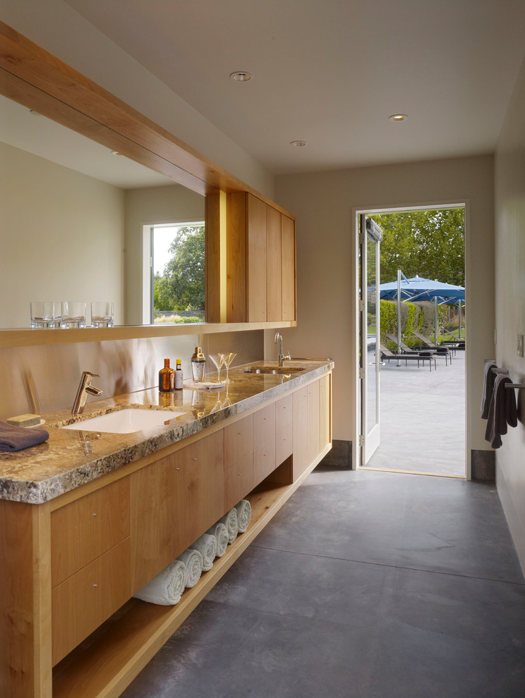 На фото: маленькая главная ванная комната в стиле модернизм с врезной раковиной, плоскими фасадами, фасадами цвета дерева среднего тона, бетонным полом, бежевыми стенами и серым полом для на участке и в саду с