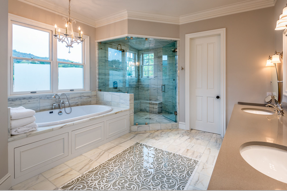На фото: большая главная ванная комната в классическом стиле с фасадами с утопленной филенкой, белыми фасадами, накладной ванной, душем в нише, коричневыми стенами, мраморным полом, врезной раковиной и столешницей из искусственного камня