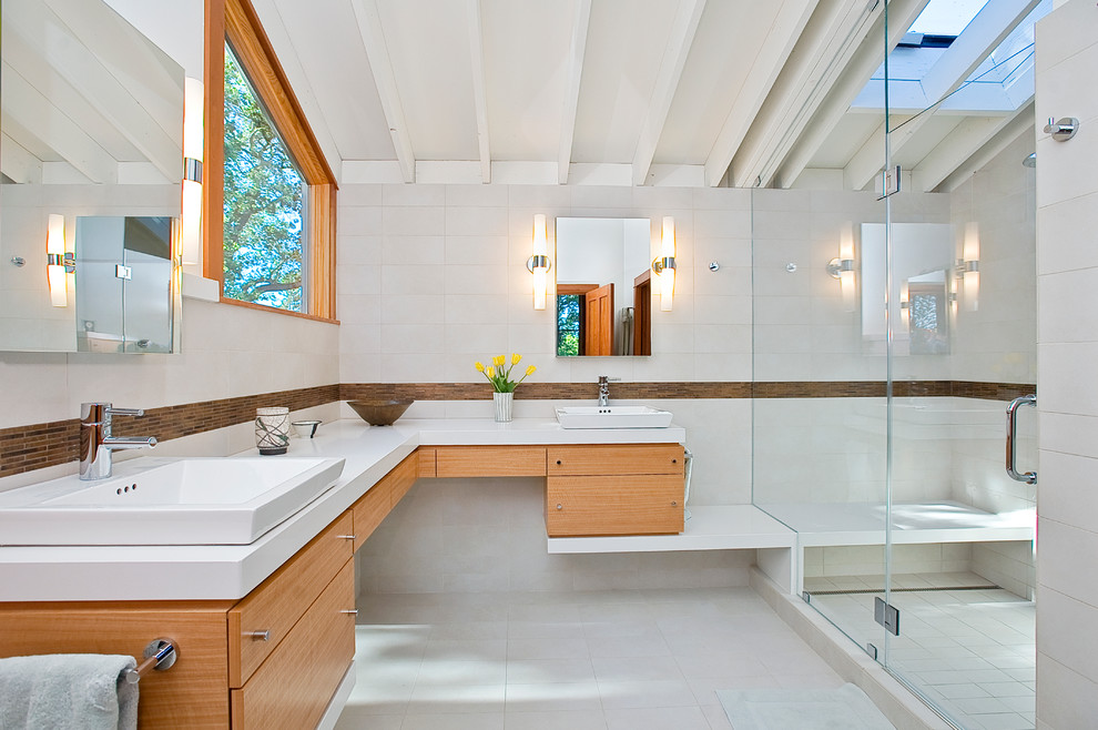 Inredning av ett modernt mellanstort vit vitt en-suite badrum, med en öppen dusch, ett fristående handfat, släta luckor, bänkskiva i kvarts, vit kakel, porslinskakel, vita väggar, klinkergolv i porslin, skåp i mellenmörkt trä och dusch med gångjärnsdörr