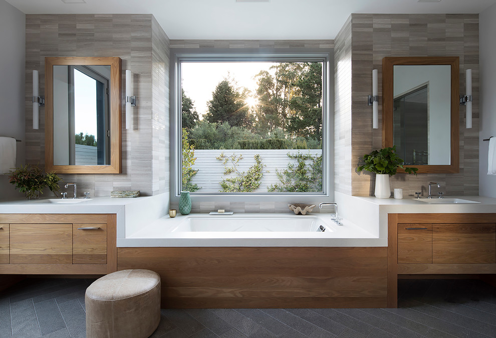 Design ideas for a rural ensuite bathroom in San Francisco with flat-panel cabinets, medium wood cabinets, a submerged bath, beige tiles, a submerged sink, grey floors and white worktops.