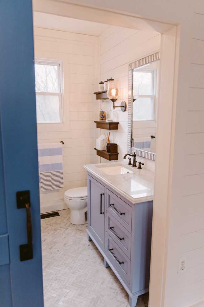 Design ideas for a small coastal family bathroom in Baltimore with beaded cabinets, blue cabinets, an alcove bath, an alcove shower, a one-piece toilet, white tiles, metro tiles, white walls, marble flooring, a built-in sink, engineered stone worktops, grey floors, a shower curtain, white worktops, a single sink, a built in vanity unit and tongue and groove walls.