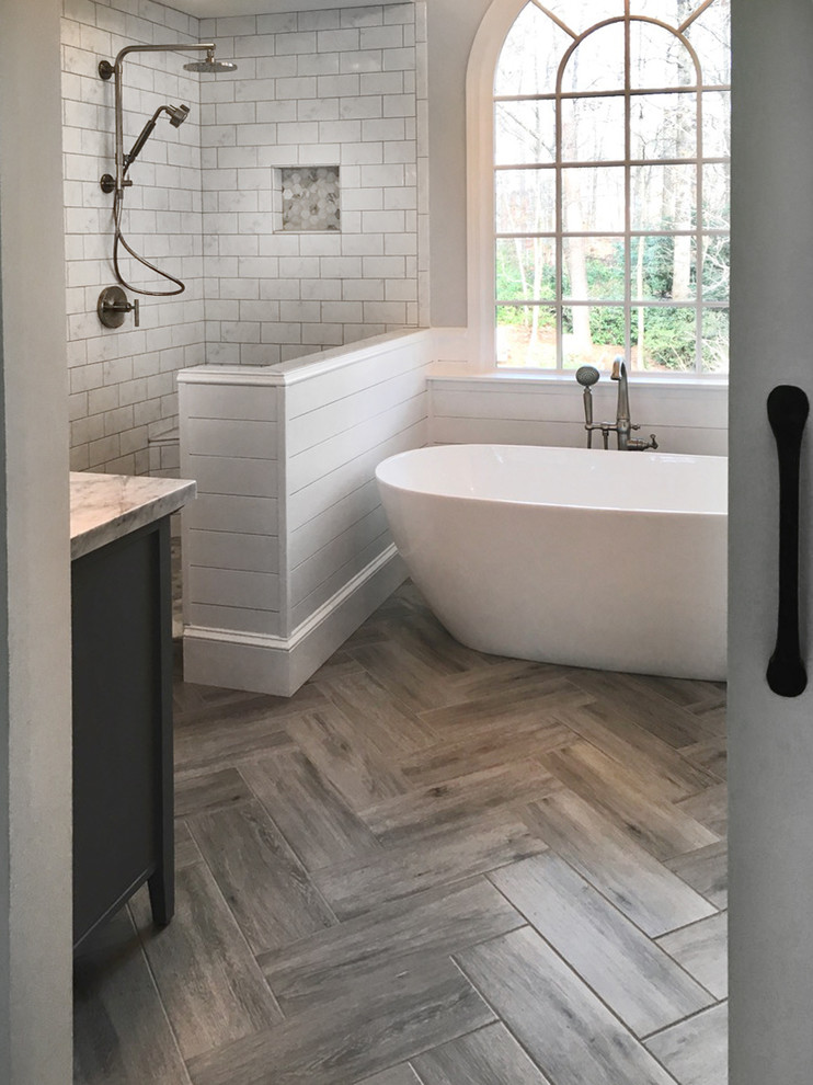 Medium sized country ensuite bathroom in Atlanta with shaker cabinets, grey cabinets, a freestanding bath, a corner shower, a two-piece toilet, white tiles, ceramic tiles, grey walls, ceramic flooring, a submerged sink, marble worktops, grey floors and a hinged door.