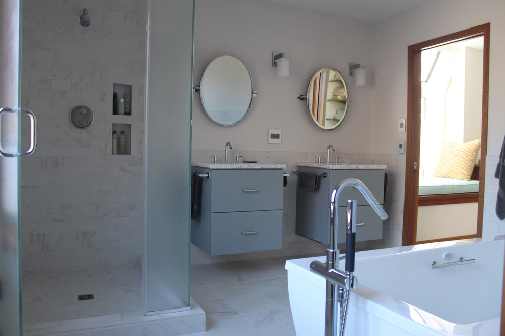 Immagine di una grande stanza da bagno padronale minimal con ante lisce, vasca freestanding, doccia ad angolo, WC sospeso e lavabo sottopiano