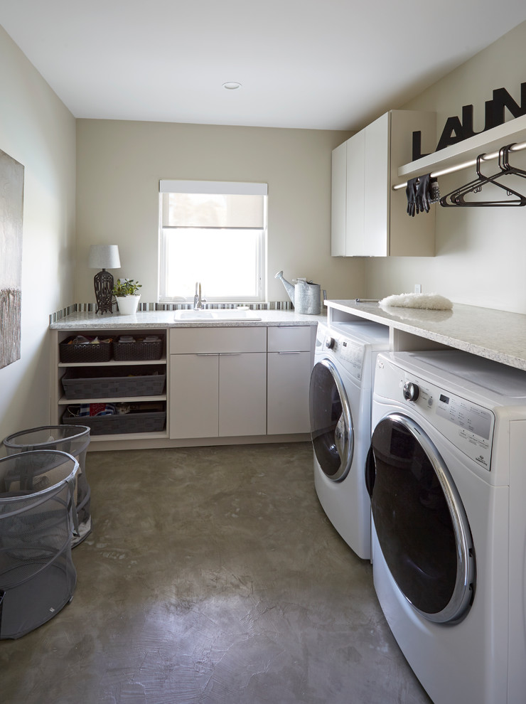 Foto di una grande lavanderia minimal con ante lisce, ante grigie, pareti beige, pavimento in gres porcellanato e pavimento bianco