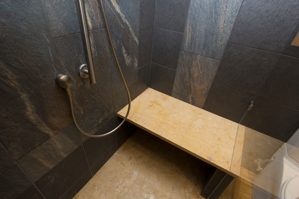 This is an example of a medium sized contemporary ensuite bathroom in Raleigh with a vessel sink, flat-panel cabinets, light wood cabinets, wooden worktops, a built-in shower, a two-piece toilet, black tiles, porcelain tiles, yellow walls, bamboo flooring, yellow floors, a hinged door and yellow worktops.