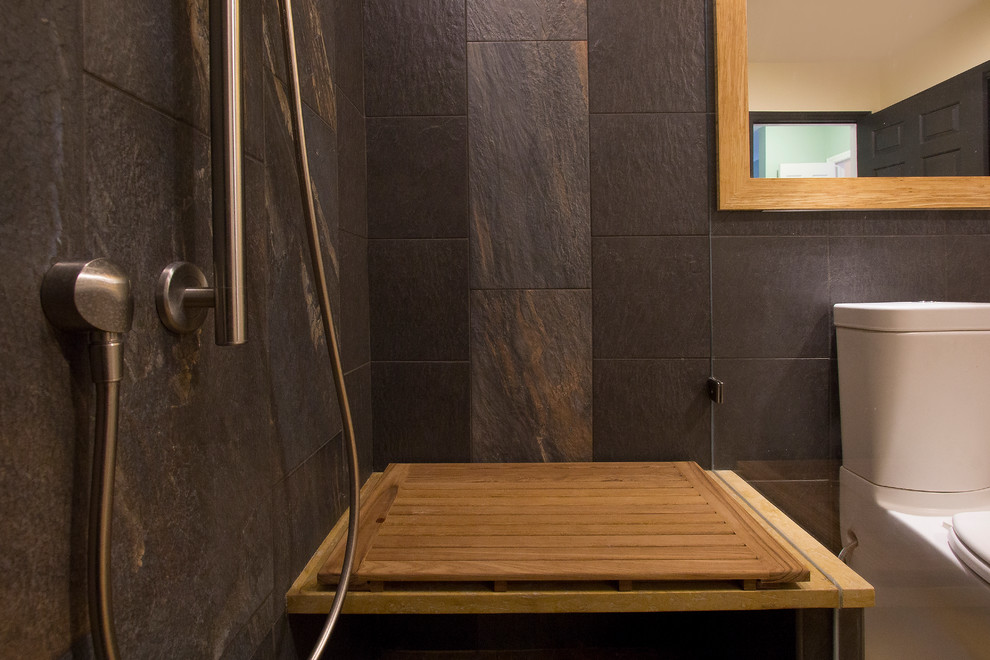 Inspiration for a medium sized contemporary ensuite bathroom in Raleigh with a vessel sink, flat-panel cabinets, light wood cabinets, wooden worktops, a built-in shower, a two-piece toilet, black tiles, porcelain tiles, yellow walls, bamboo flooring, yellow floors, a hinged door and yellow worktops.