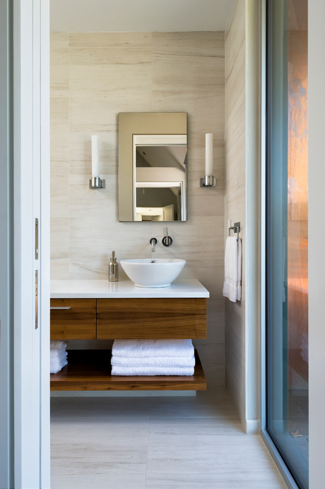 Réalisation d'une petite salle de bain design en bois brun avec une vasque, un placard à porte plane, un plan de toilette en quartz modifié, un carrelage beige, un carrelage de pierre, un mur beige et un sol beige.
