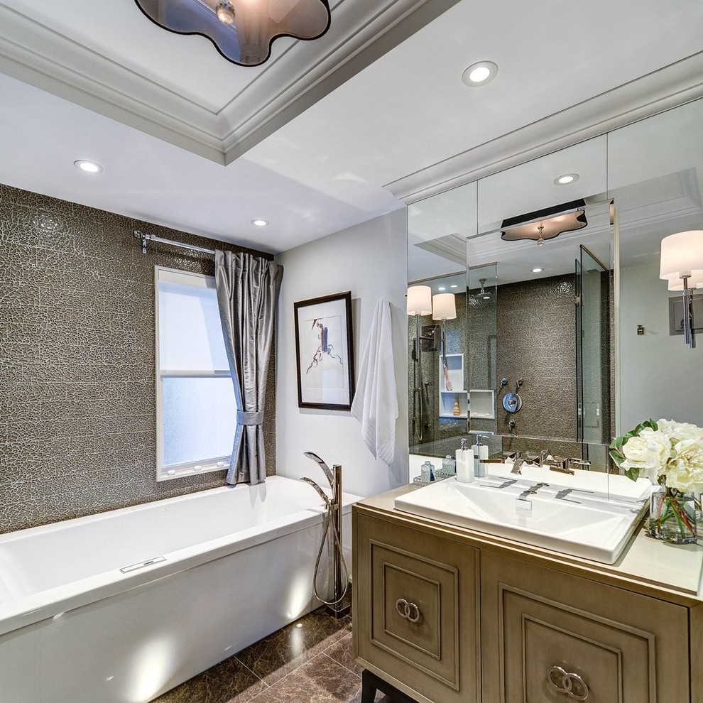 Imagen de cuarto de baño contemporáneo con lavabo encastrado, puertas de armario de madera oscura, bañera empotrada y baldosas y/o azulejos grises