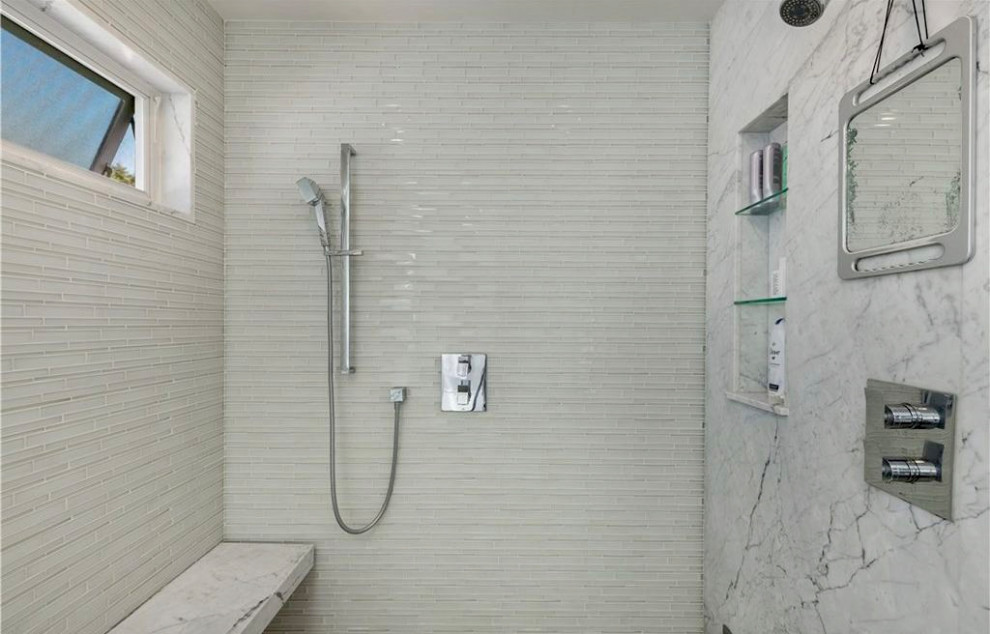 Exemple d'une grande salle de bain principale tendance avec un placard à porte plane, des portes de placard grises, une baignoire encastrée, une douche à l'italienne, WC à poser, un carrelage blanc, un carrelage en pâte de verre, un mur blanc, un sol en carrelage de porcelaine, un lavabo encastré, un plan de toilette en marbre, un sol gris, une cabine de douche à porte battante, un plan de toilette blanc, des toilettes cachées, meuble double vasque et meuble-lavabo suspendu.