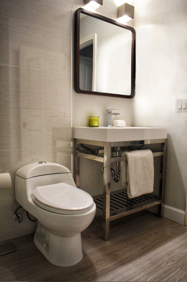 Example of a small minimalist 3/4 white tile and porcelain tile porcelain tile and brown floor alcove shower design in Sacramento with open cabinets, a one-piece toilet, white walls, an integrated sink, solid surface countertops, a hinged shower door and white countertops