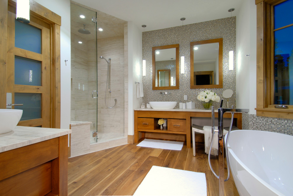 Exempel på ett modernt badrum, med ett fristående handfat, skåp i mellenmörkt trä, ett fristående badkar, en hörndusch och mosaik