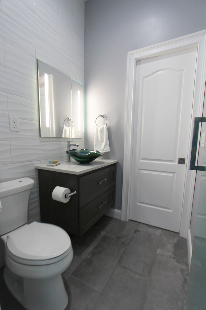 Exemple d'une salle de bain tendance en bois foncé de taille moyenne pour enfant avec un placard à porte affleurante, une douche double, WC séparés, un carrelage blanc, des carreaux de céramique, un mur gris, un sol en carrelage de porcelaine, une vasque, un plan de toilette en quartz modifié, un sol gris, une cabine de douche à porte battante et un plan de toilette blanc.