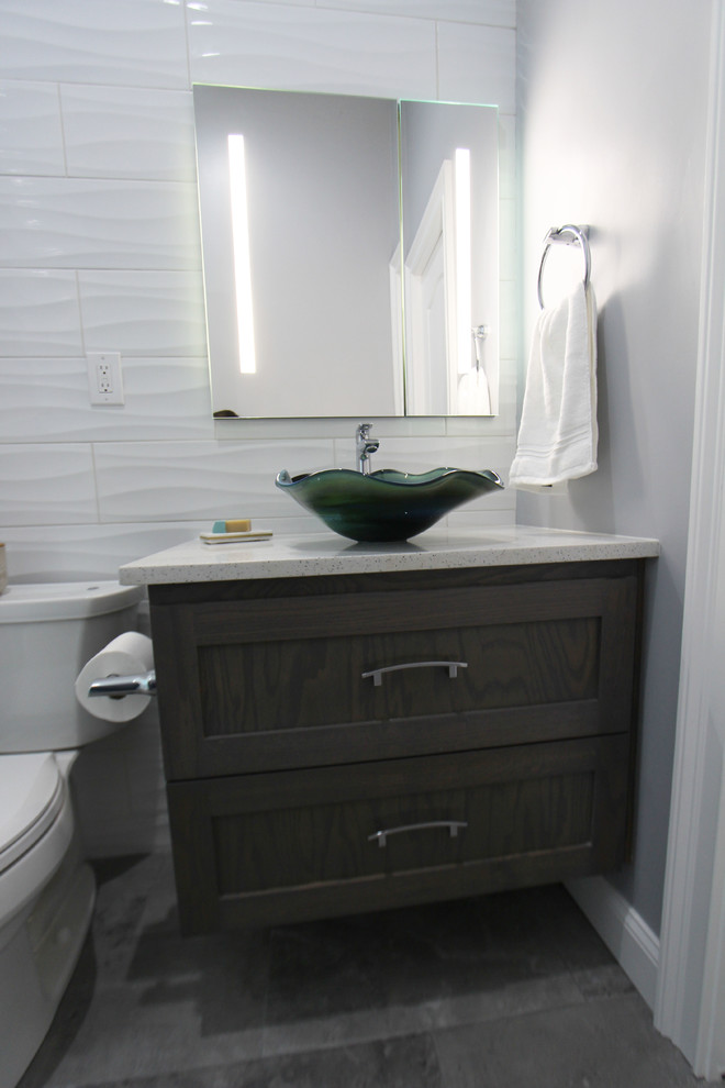 Example of a mid-sized trendy kids' white tile and ceramic tile porcelain tile and gray floor double shower design in Atlanta with beaded inset cabinets, dark wood cabinets, a two-piece toilet, gray walls, a vessel sink, quartz countertops, a hinged shower door and white countertops