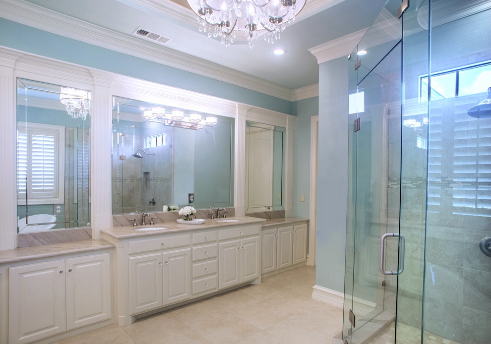 Bathroom - mid-sized traditional master beige tile and ceramic tile ceramic tile and beige floor bathroom idea in Dallas with raised-panel cabinets, white cabinets, blue walls, an undermount sink, quartz countertops and a hinged shower door