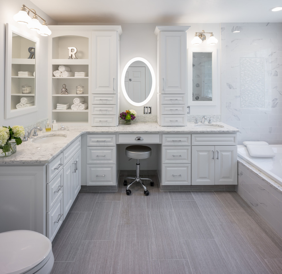 Traditional ensuite bathroom in Providence with raised-panel cabinets, white cabinets, a built-in bath, a corner shower, a two-piece toilet, porcelain tiles, white walls, porcelain flooring, a submerged sink, engineered stone worktops, grey floors and a hinged door.