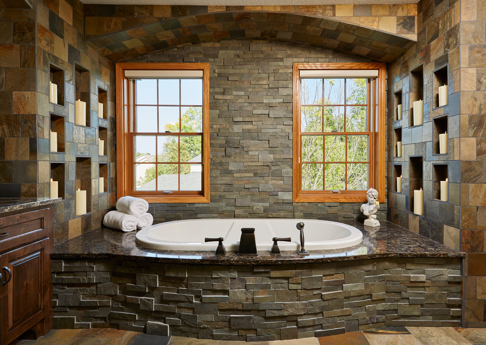 Cette image montre une grande salle de bain principale traditionnelle avec une baignoire posée, un carrelage multicolore et un sol multicolore.