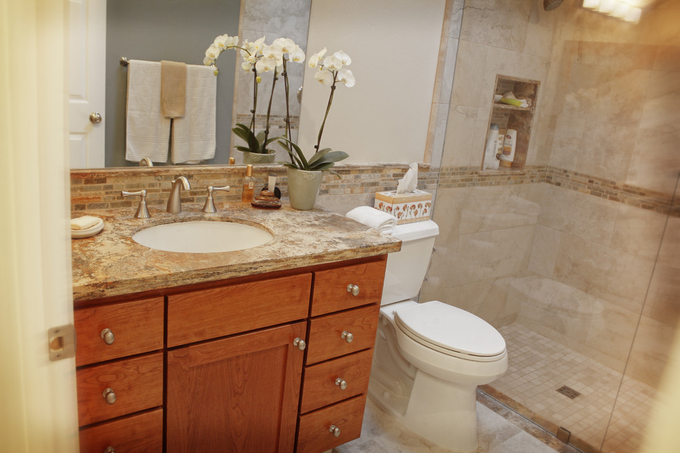 Example of a trendy brown tile and stone tile alcove shower design in San Francisco with an undermount sink, raised-panel cabinets, dark wood cabinets, granite countertops and a one-piece toilet