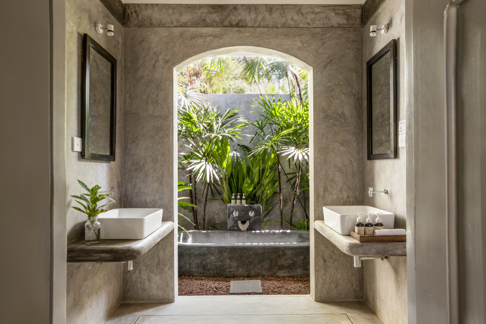 Foto di una stanza da bagno tropicale con pareti grigie, lavabo a bacinella, pavimento grigio, top grigio e due lavabi