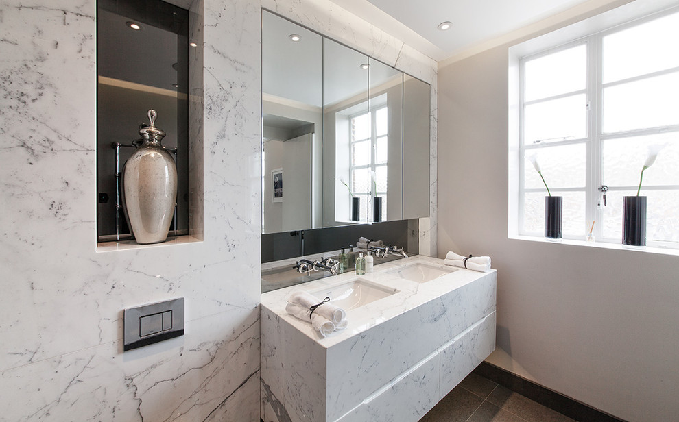 Exemple d'une petite salle de bain principale rétro avec un placard à porte plane, des portes de placard blanches, une douche ouverte, WC à poser, un carrelage gris, des carreaux de miroir, un mur gris, un sol en marbre, un lavabo encastré et un plan de toilette en marbre.