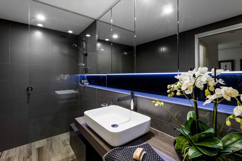 Inspiration for a medium sized modern family bathroom in Brisbane with freestanding cabinets, distressed cabinets, a built-in shower, a wall mounted toilet, brown tiles, porcelain tiles, brown walls, ceramic flooring, a vessel sink and laminate worktops.