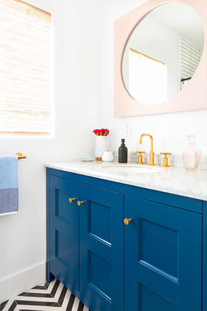 Modelo de cuarto de baño azulejo de dos tonos clásico renovado con armarios con paneles empotrados, puertas de armario azules, paredes blancas, lavabo bajoencimera y suelo multicolor