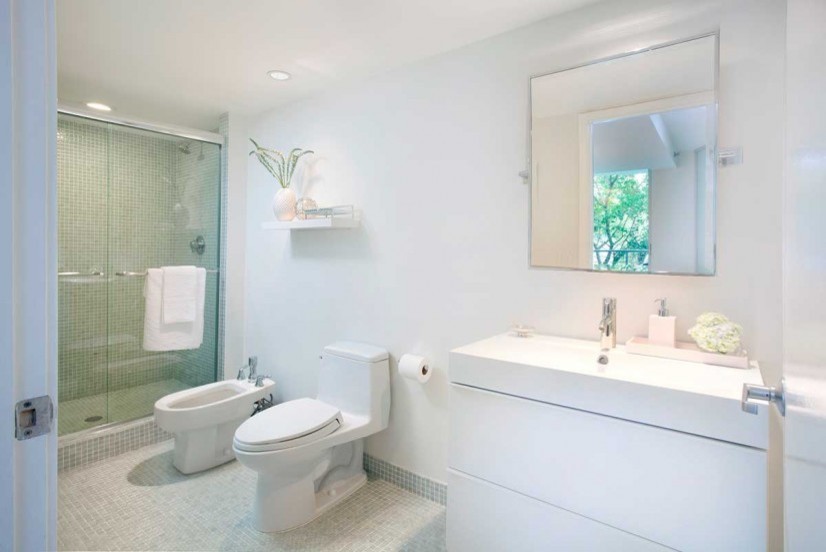 Bild på ett mellanstort maritimt badrum, med ett undermonterad handfat, släta luckor, vita skåp, bänkskiva i kvartsit, en öppen dusch, en toalettstol med hel cisternkåpa, vit kakel, mosaik, vita väggar och mosaikgolv