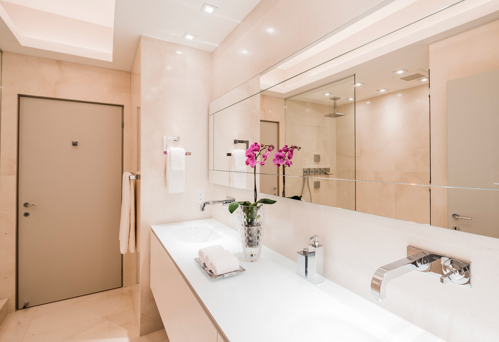 Стильный дизайн: большая главная ванная комната в современном стиле с плоскими фасадами, белыми фасадами, угловой ванной, открытым душем, унитазом-моноблоком, белой плиткой, плиткой из листового стекла, бежевыми стенами, полом из керамической плитки, накладной раковиной, стеклянной столешницей и бежевым полом - последний тренд