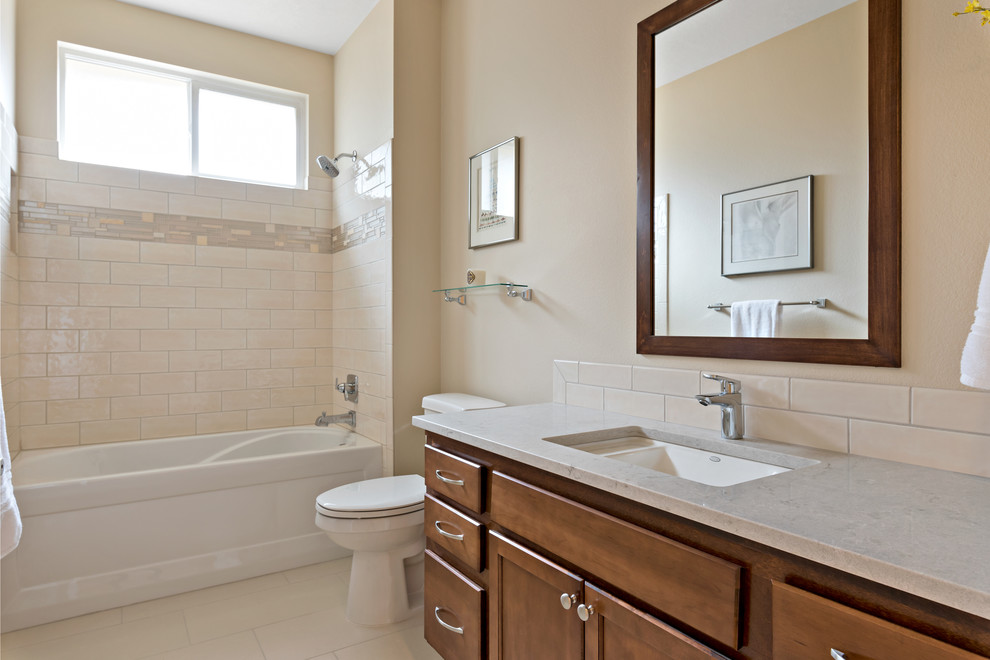Idéer för att renovera ett mellanstort vintage grå grått en-suite badrum, med skåp i shakerstil, skåp i mellenmörkt trä, ett badkar i en alkov, en dusch i en alkov, en toalettstol med separat cisternkåpa, vit kakel, keramikplattor, beige väggar, klinkergolv i porslin, ett undermonterad handfat, bänkskiva i kvarts, vitt golv och dusch med duschdraperi