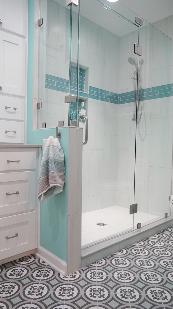Alcove shower - mid-sized coastal master blue tile and glass tile porcelain tile and multicolored floor alcove shower idea with shaker cabinets, white cabinets, blue walls, an undermount sink, quartzite countertops, a hinged shower door and gray countertops