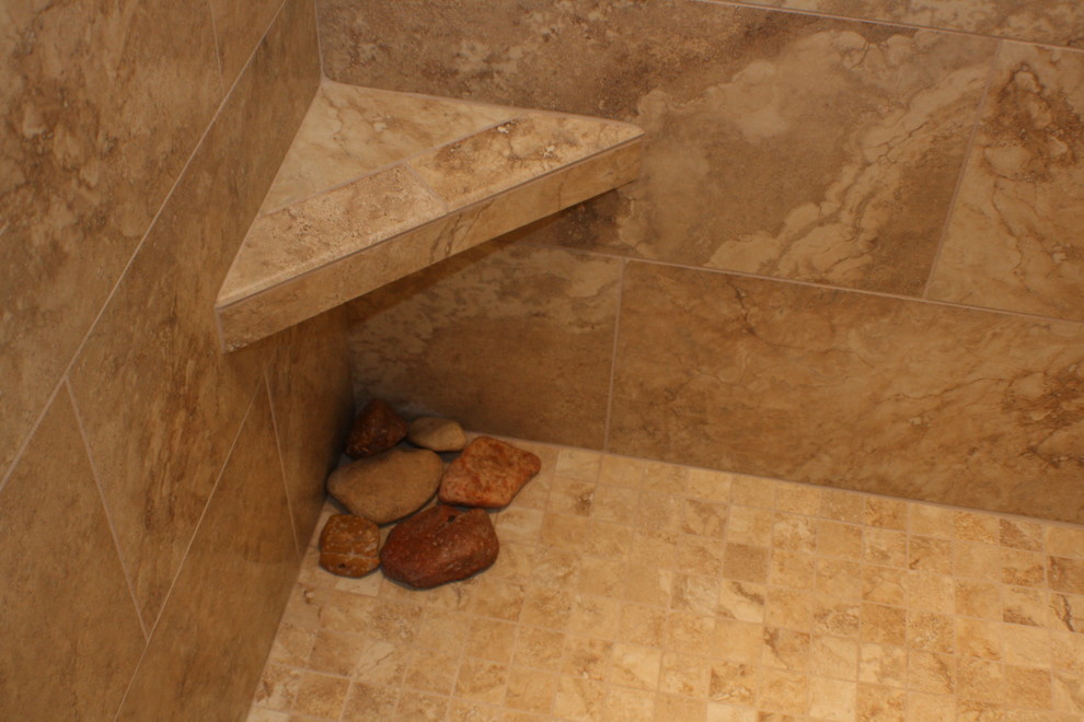 Example of a small classic stone tile alcove shower design in Boise with an undermount sink, raised-panel cabinets, marble countertops, a two-piece toilet and yellow walls