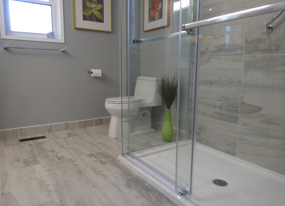 Inspiration pour une salle de bain design de taille moyenne avec un placard à porte shaker, des portes de placard blanches, une douche d'angle, WC à poser, un carrelage gris, des carreaux de porcelaine, un mur gris, un sol en carrelage de porcelaine, un lavabo encastré et un plan de toilette en quartz modifié.