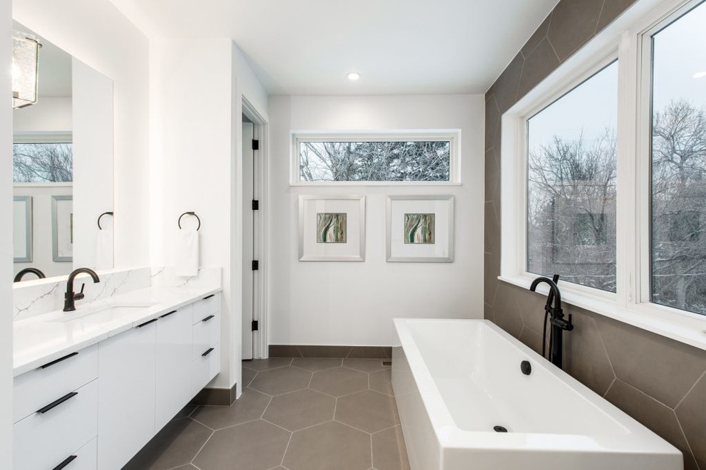Foto di una stanza da bagno padronale minimalista di medie dimensioni con ante lisce, ante bianche, vasca freestanding, piastrelle grigie, pareti bianche, lavabo sottopiano, top in marmo, pavimento grigio e top bianco